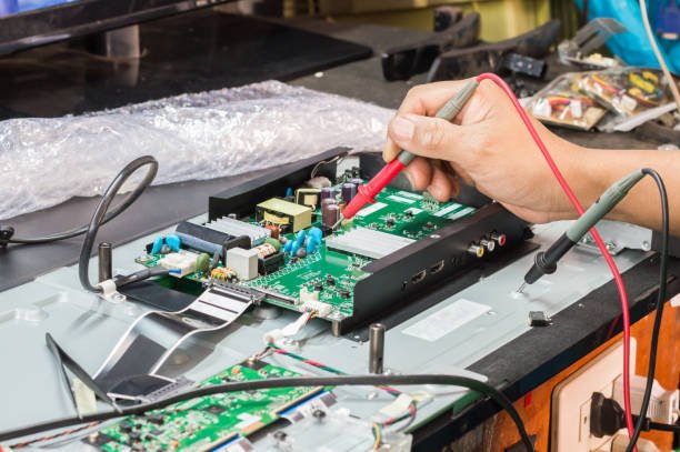 Close-up of a TV circuit board being tested with a probe